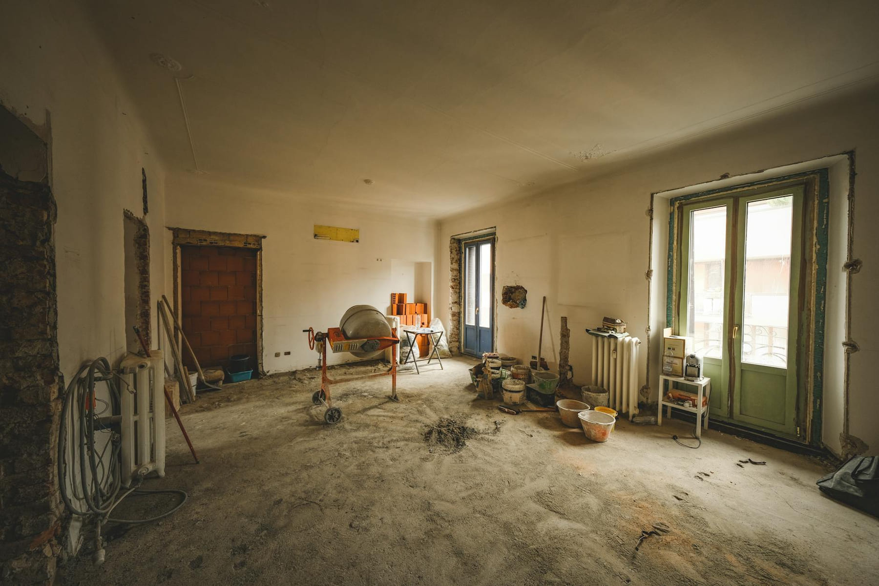 Wide view of a sunny room under renovation with construction materials and tools present, ideal for home improvement concepts. on Hammer & Home
