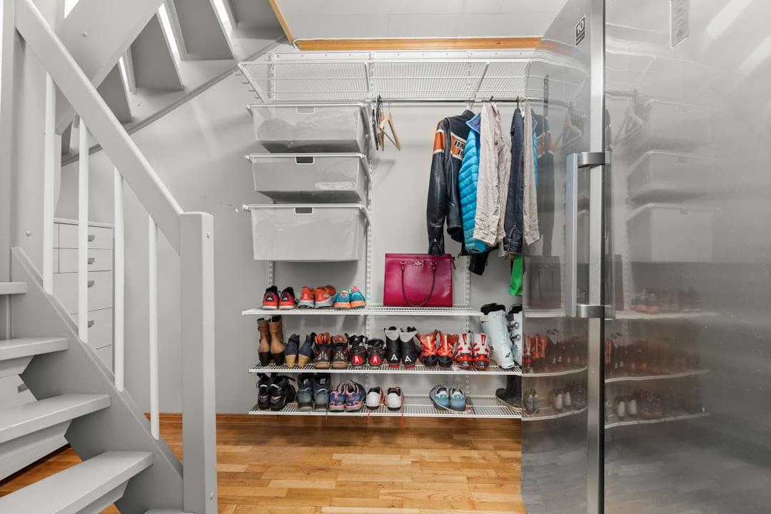A walk in closet with a lot of shoes on Hammer & Home