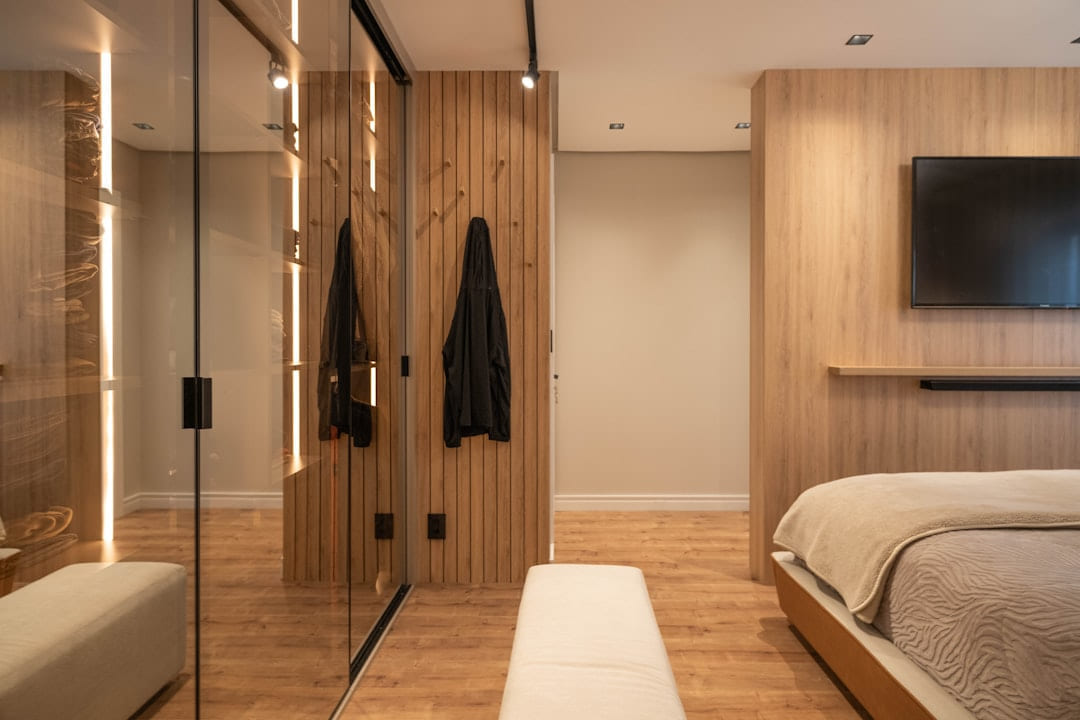 A modern bedroom with wood and a mirrored closet. on Hammer & Home