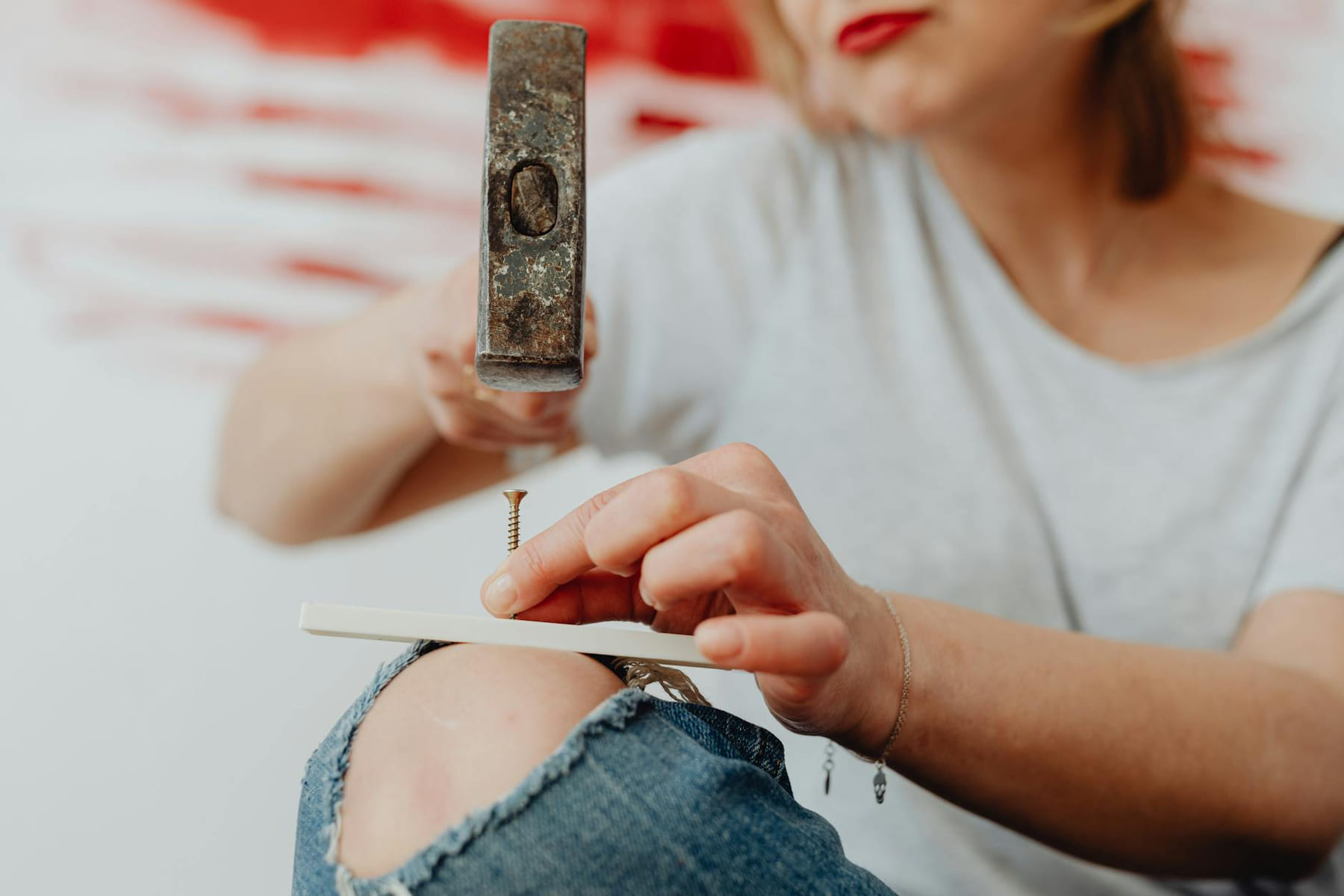 Woman uses a hammer and nail for DIY home improvement project. on Hammer & Home