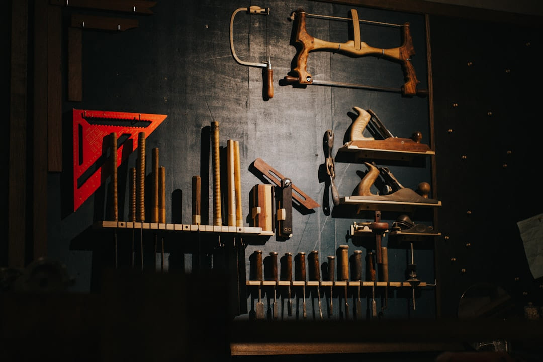 Various woodworking tools hang on a dark wall. on Hammer & Home